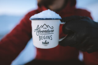 person-holding-mug-adventure-begins