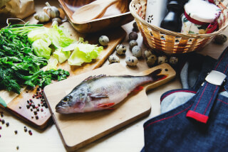 raw-fish-on-cutting-board-with-lettuce-in-kitchen