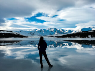 silhouette-photo-of-woman-facing-snow-capped-mountain